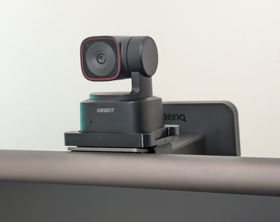 The mount clipped to the light bar, holding the webcam above the monitor.